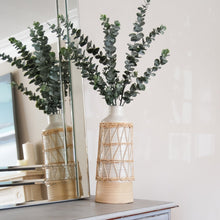 Load image into Gallery viewer, Two tone ribbed vase with rattan sleeve and eucalyptus on table.
