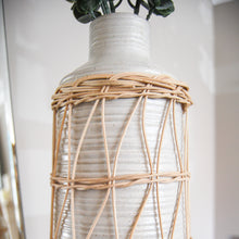 Load image into Gallery viewer, Close up of ribbed vase and rattan sleeve.
